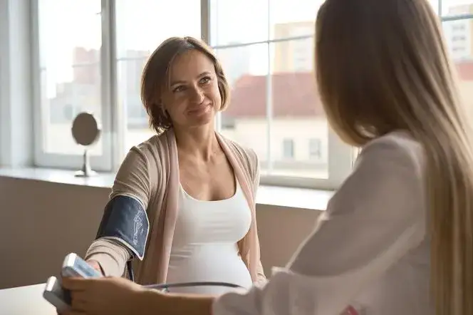 kobieta w ciąży mierząca ciśnienie krwi